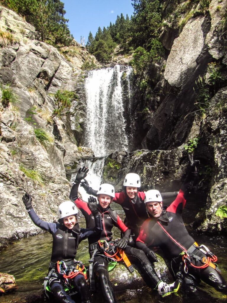 famille heureuse en canyon dans le pyrenees orientales, grande cascade en fond d'image